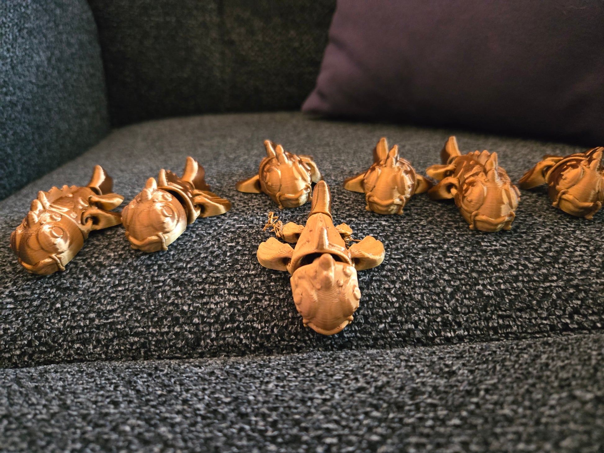 Mini Koi Companions 3D printed articulated figurines – group of golden koi fish figurines displayed on a couch