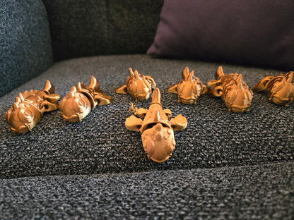 Mini Koi Companions 3D printed articulated figurines – group of golden koi fish figurines displayed on a couch