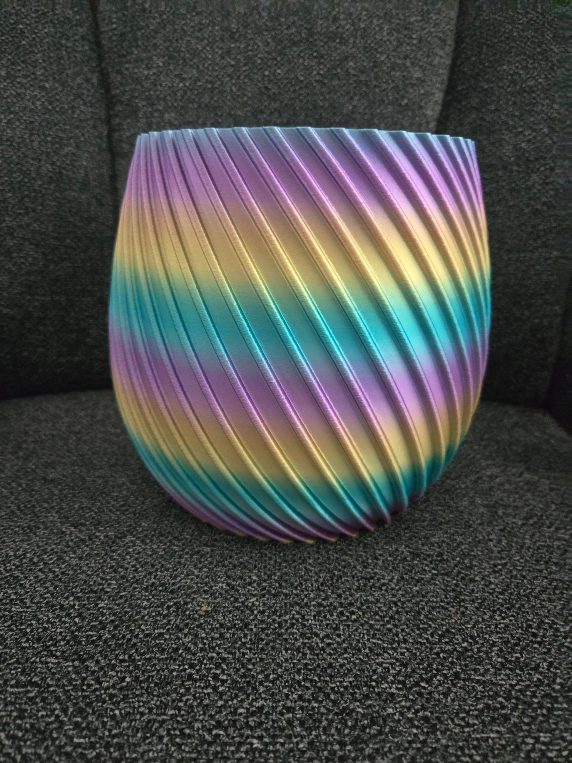 3D printed spiral flower pot in rainbow silk filament, exterior view showing diagonal ridged texture