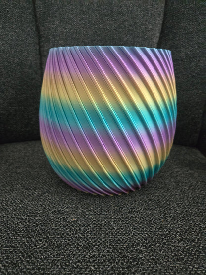3D printed spiral flower pot in rainbow silk filament, exterior view showing diagonal ridged texture