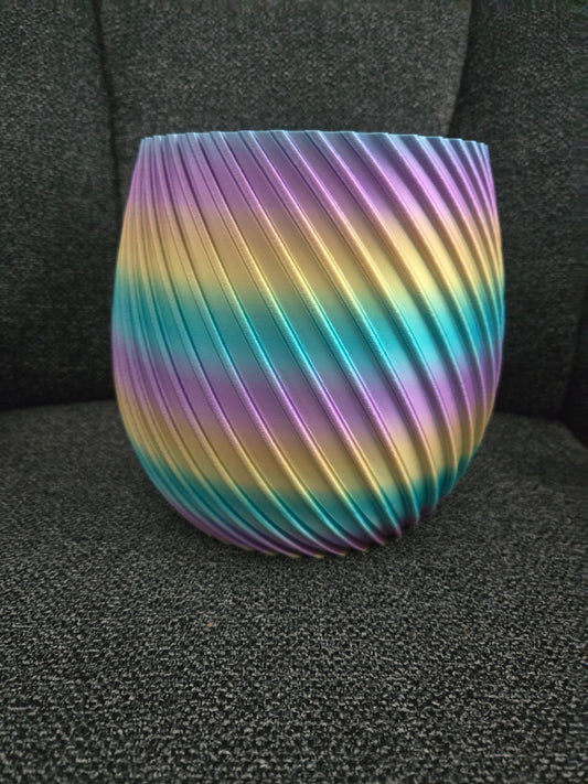 3D printed spiral flower pot in rainbow silk filament, exterior view showing diagonal ridged texture
