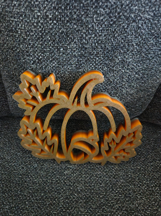 3D printed Pumpkin Harvest Scene in multicolor blended orange-to-gold filament, front view showing pumpkin with acorn and maple leaves open-frame silhouette